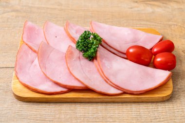 Ahşap tahta üzerinde dilimlenmiş jambon füme