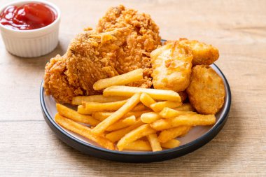 Kızarmış tavuk, patates kızartması ve nugget yemeği. Abur cubur ve sağlıksız yemek.