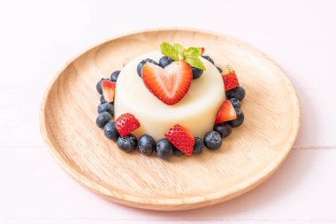 yoğurt puding plaka üzerinde bir yaban mersini ve taze çilek ile