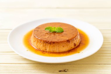 Ev yapımı karamel kremalı puding ahşap arka plan üzerinde