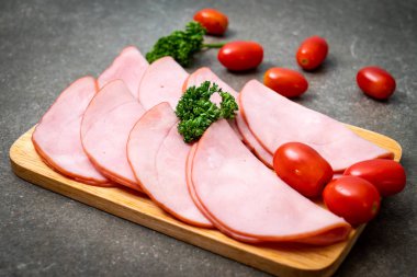 Ahşap tahta üzerinde dilimlenmiş jambon füme