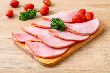 Ahşap tahta üzerinde dilimlenmiş jambon füme