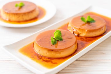 Ev yapımı karamel kremalı puding ahşap arka plan üzerinde