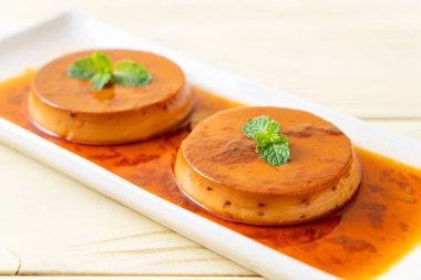 Ev yapımı karamel kremalı puding ahşap arka plan üzerinde