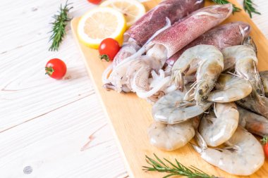 taze deniz ürünleri ham (karides, mürekkep) malzemelerle ahşap tahta üzerinde