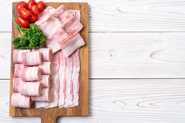 Ahşap tahta üzerinde çiğ domuz pastırma dilimlenmiş
