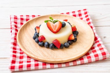 yoğurt puding plaka üzerinde bir yaban mersini ve taze çilek ile
