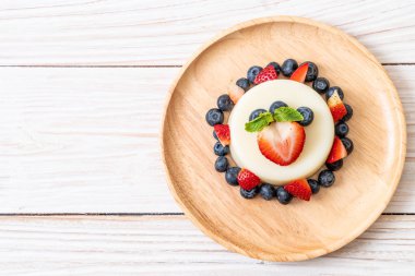 yoğurt puding plaka üzerinde bir yaban mersini ve taze çilek ile