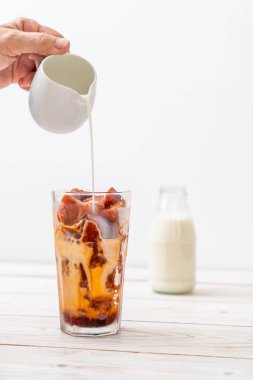 Tay çay buz küpü ile ahşap arka plan üzerinde süt