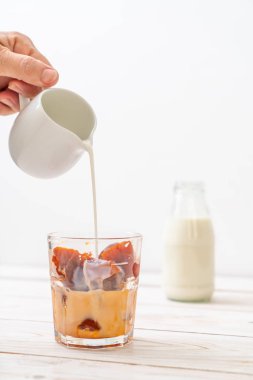 Tay çay buz küpü ile ahşap arka plan üzerinde süt