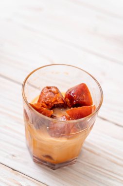 Tay çay buz küpü ile ahşap arka plan üzerinde süt