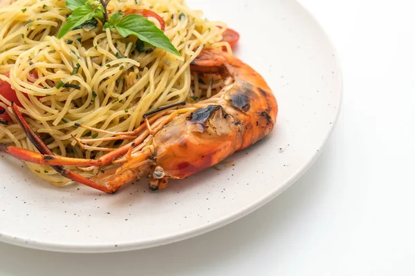 ızgara karides ve beyaz arka plan üzerinde izole domates ile tavada kızartılmış spagetti