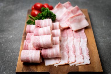 Ahşap tahta üzerinde çiğ domuz pastırma dilimlenmiş