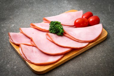 Ahşap tahta üzerinde dilimlenmiş jambon füme