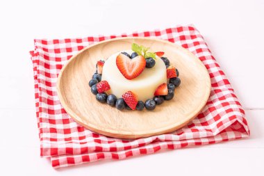 yoğurt puding plaka üzerinde bir yaban mersini ve taze çilek ile