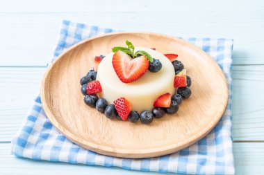 yoğurt puding plaka üzerinde bir yaban mersini ve taze çilek ile