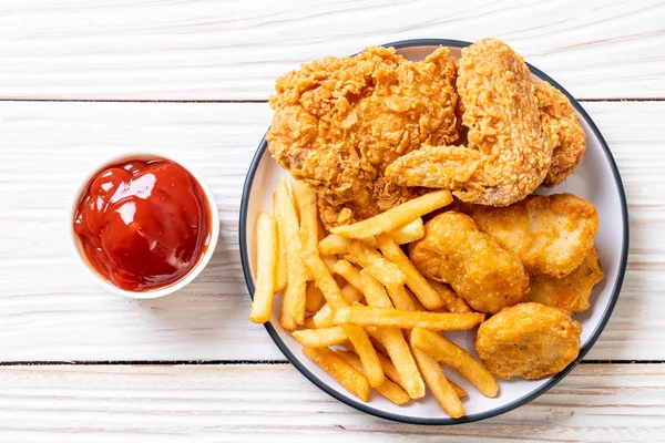 Kızarmış tavuk, patates kızartması ve nugget yemeği. Abur cubur ve sağlıksız yemek.