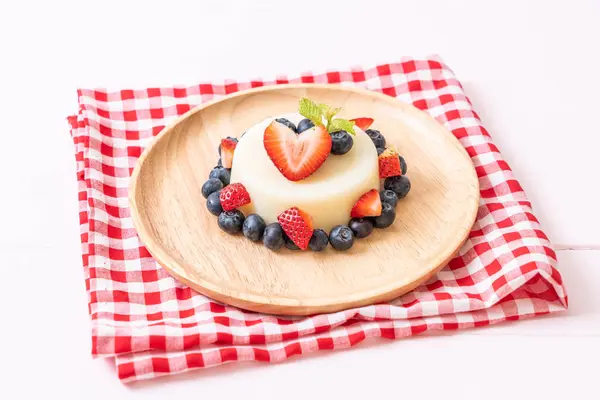 yoğurt puding plaka üzerinde bir yaban mersini ve taze çilek ile