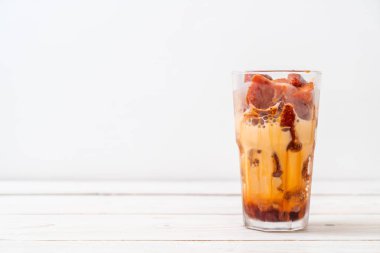 Tay çay buz küpü ile ahşap arka plan üzerinde süt