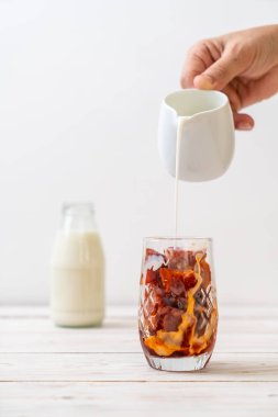 Tay çay buz küpü ile ahşap arka plan üzerinde süt