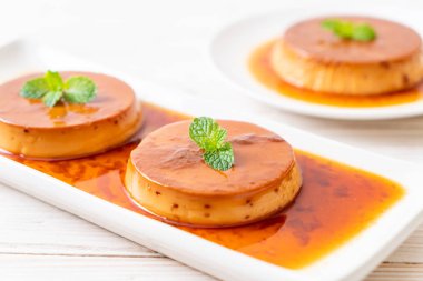 Ev yapımı karamel kremalı puding ahşap arka plan üzerinde