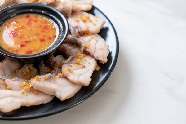 Soslu ve sebzeli haşlanmış balık sosu.