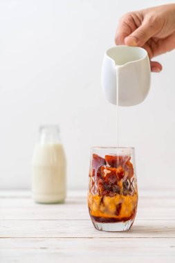 Tay çay buz küpü ile ahşap arka plan üzerinde süt