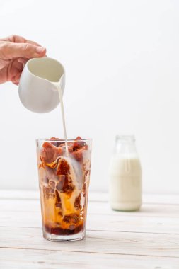 Tay çay buz küpü ile ahşap arka plan üzerinde süt