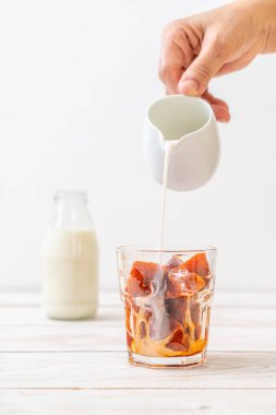 Tay çay buz küpü ile ahşap arka plan üzerinde süt