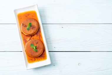 Ev yapımı karamel kremalı puding ahşap arka plan üzerinde