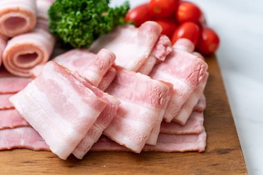 Ahşap tahta üzerinde çiğ domuz pastırma dilimlenmiş