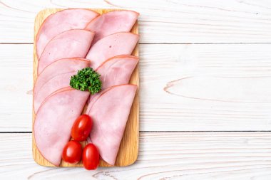 Ahşap tahta üzerinde dilimlenmiş jambon füme