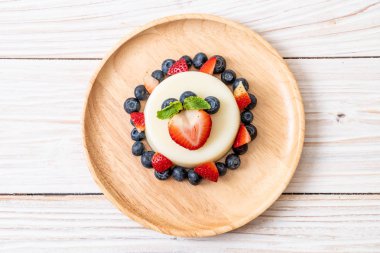 yoğurt puding plaka üzerinde bir yaban mersini ve taze çilek ile