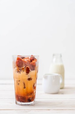 Tay çay buz küpü ile ahşap arka plan üzerinde süt