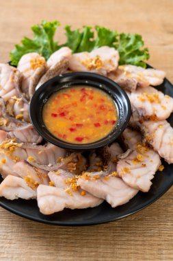 Soslu ve sebzeli haşlanmış balık sosu.