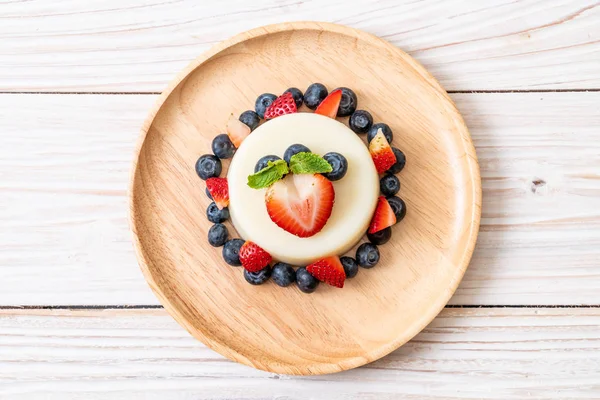 yoğurt puding plaka üzerinde bir yaban mersini ve taze çilek ile