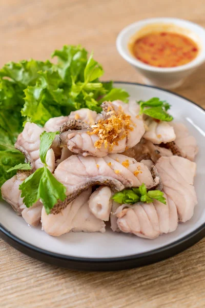 Soslu ve sebzeli haşlanmış balık sosu.