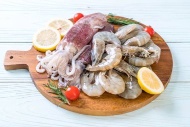 taze deniz ürünleri ham (karides, mürekkep) malzemelerle ahşap tahta üzerinde