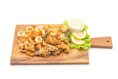 Beyaz arka plan üzerinde izole soslu kızarmış deniz ürünleri (mürekkep, karides, midye)