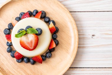 yoğurt puding plaka üzerinde bir yaban mersini ve taze çilek ile
