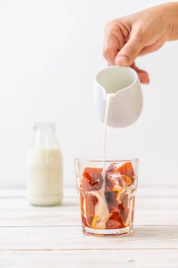 Tay çay buz küpü ile ahşap arka plan üzerinde süt