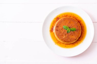 Ev yapımı karamel kremalı puding ahşap arka plan üzerinde