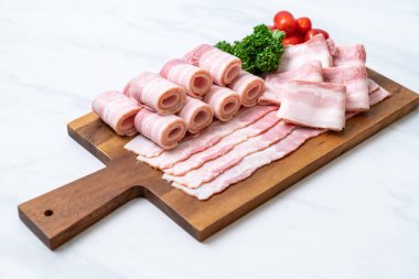 Ahşap tahta üzerinde çiğ domuz pastırma dilimlenmiş