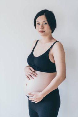 Genç güzel Asyalı hamile kadın ona dokunan karın evde - seçici odak noktası ve vintage tarzı