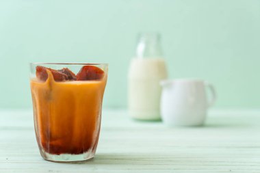 Tay çay buz küpü ile ahşap arka plan üzerinde süt