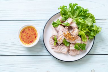 Soslu ve sebzeli haşlanmış balık sosu.