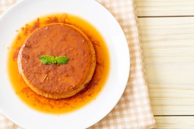 Ev yapımı karamel kremalı puding ahşap arka plan üzerinde