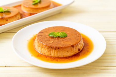 Ev yapımı karamel kremalı puding ahşap arka plan üzerinde