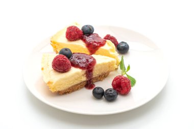 Ahududu ve beyaz arka plan üzerinde izole yaban mersini ile ev yapımı cheesecake