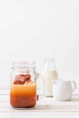 Tay çay buz küpü ile ahşap arka plan üzerinde süt